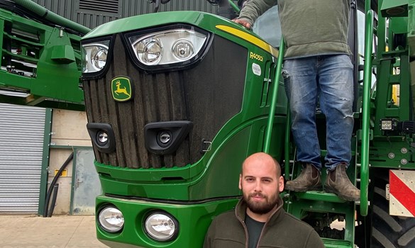 a man standing next to a green train